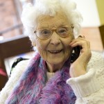 An older woman having a conversation on the telephone with a Friends of the Elderly Phoning Friends volunteer