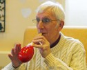 A client playing a musical instrument at a Friends of the Elderly dementia day club