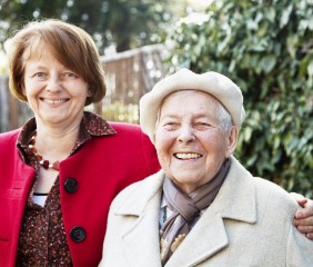 Elderly woman laughing with a friend, Friends of the Elderly befriending services