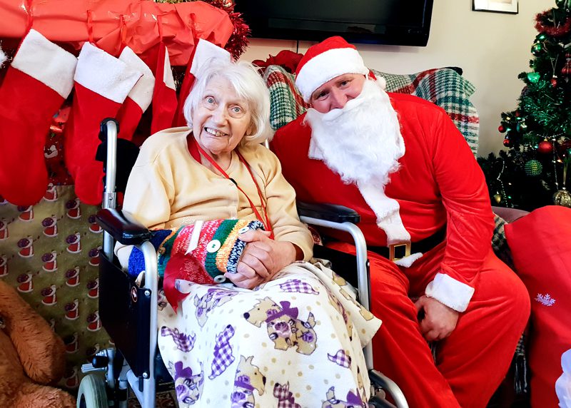 Resident sat with Father Christmas at Christmas bazaar