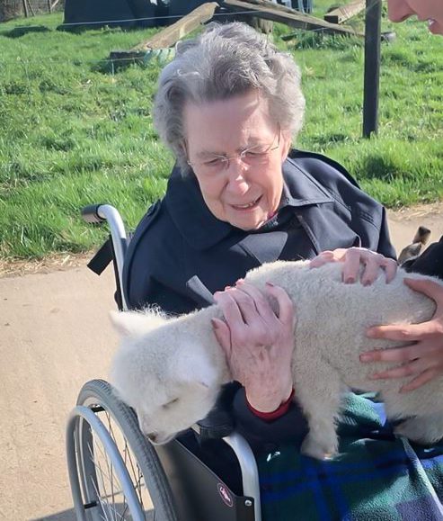 Resident from our Essex care home holding a lamb