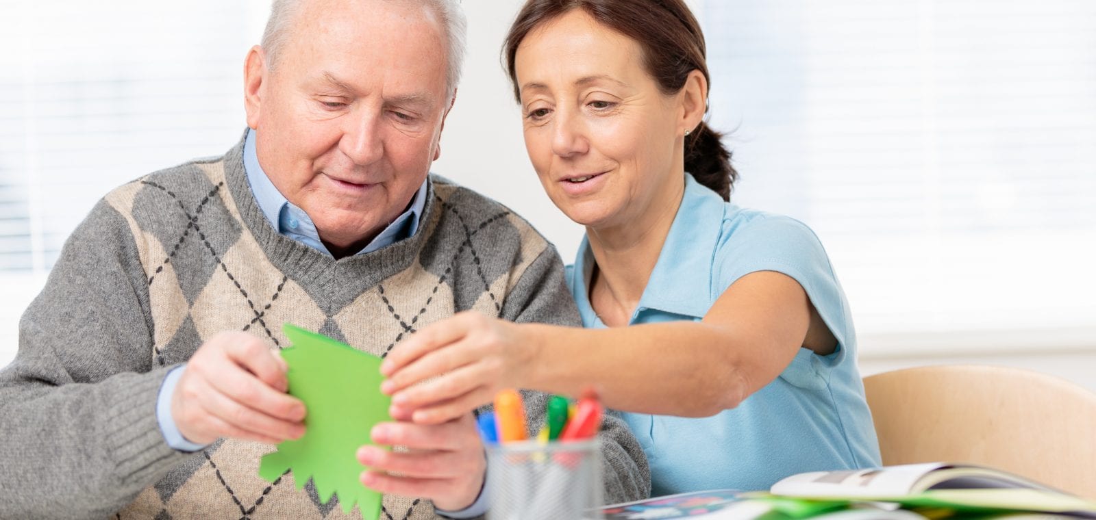 Senior man cutting paper with scissors