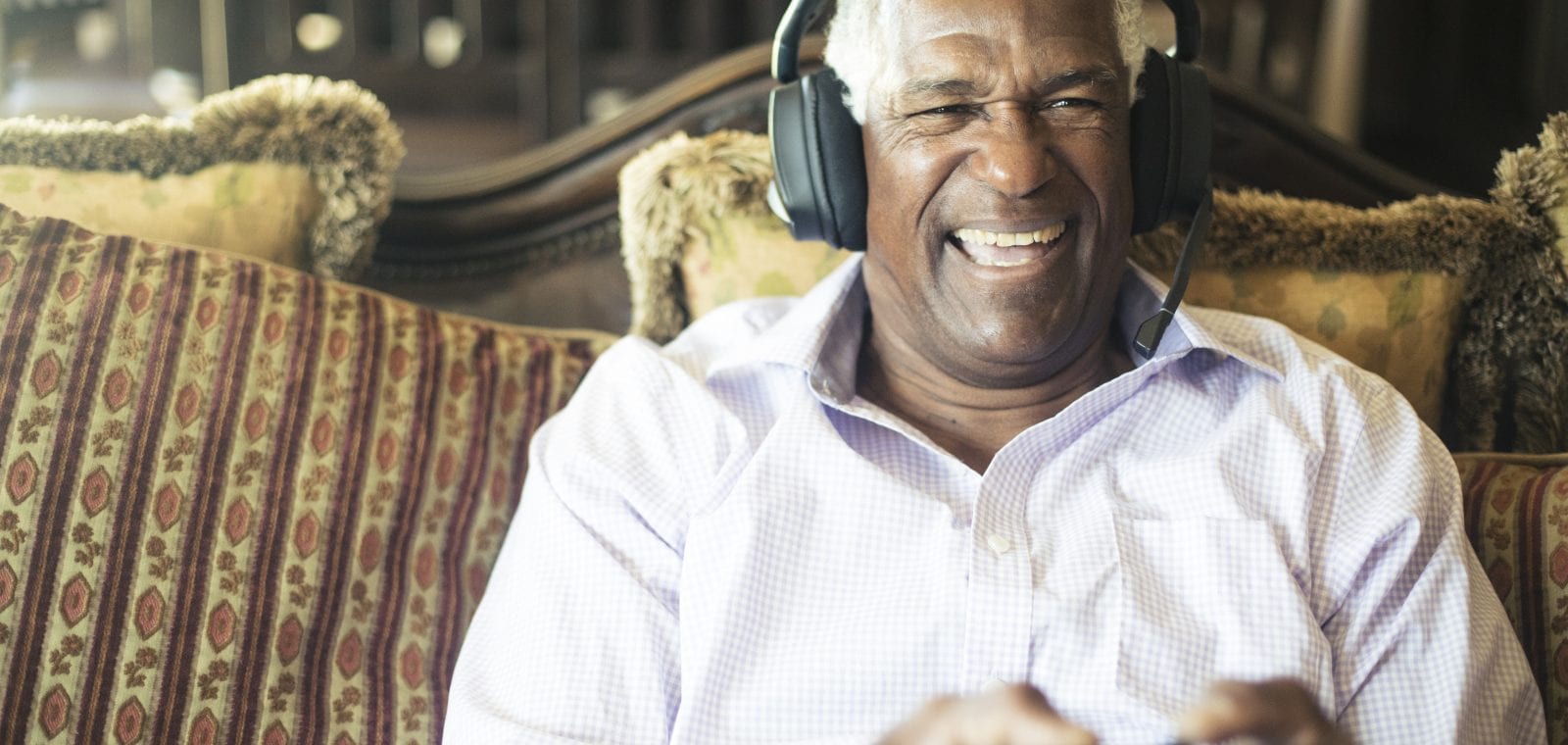 Senior Black Man Playing Video Games with Headphones