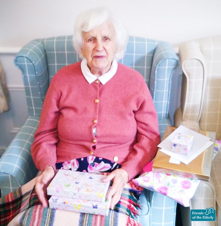 Joan on her birthday with presents on her lap. 