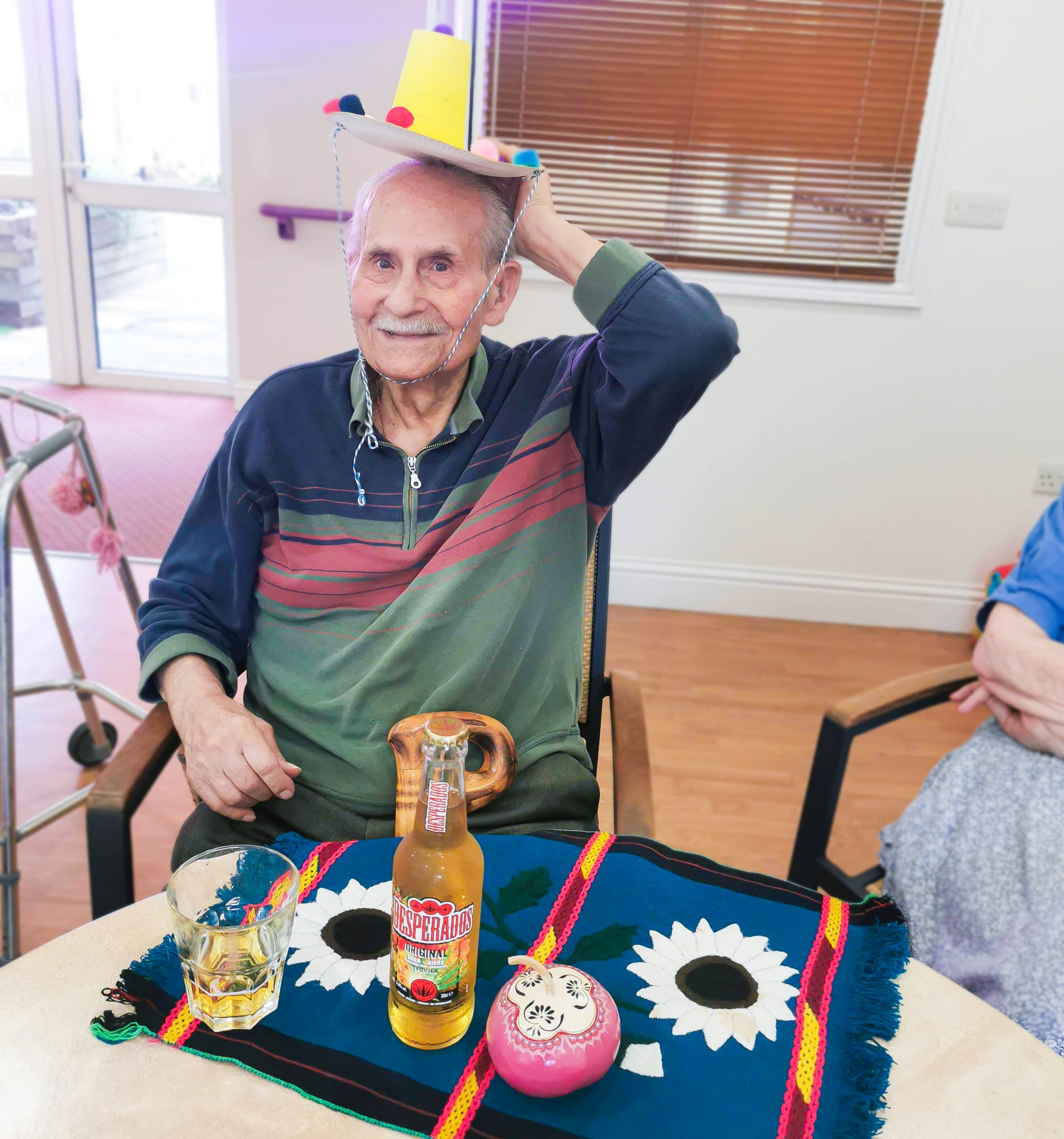 A care home resident holding a sombrero whilst travelling in Mexico