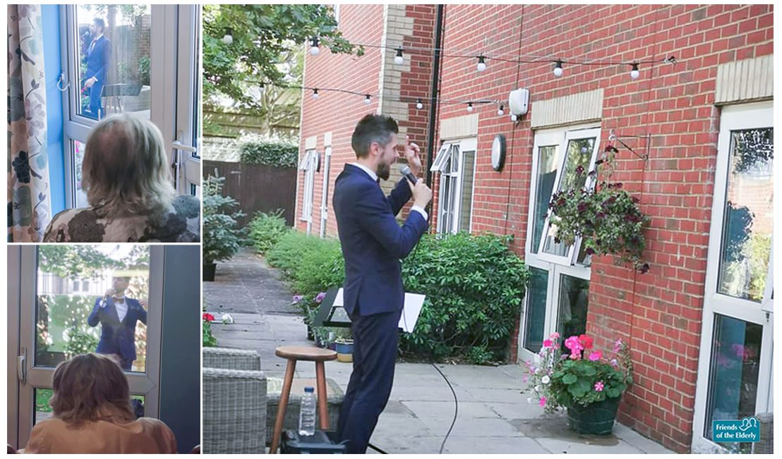 Performer Dan Brewerton sings outside as residents watch from the window inside