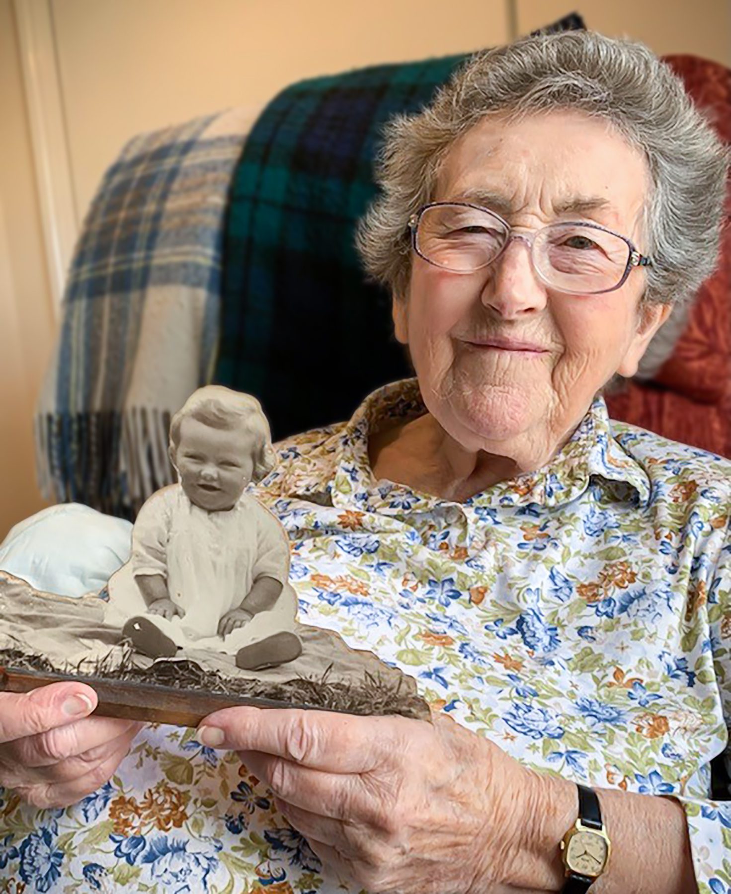 A Malvern care home resident holding a picture of herself when she was young and smiling at the camera 