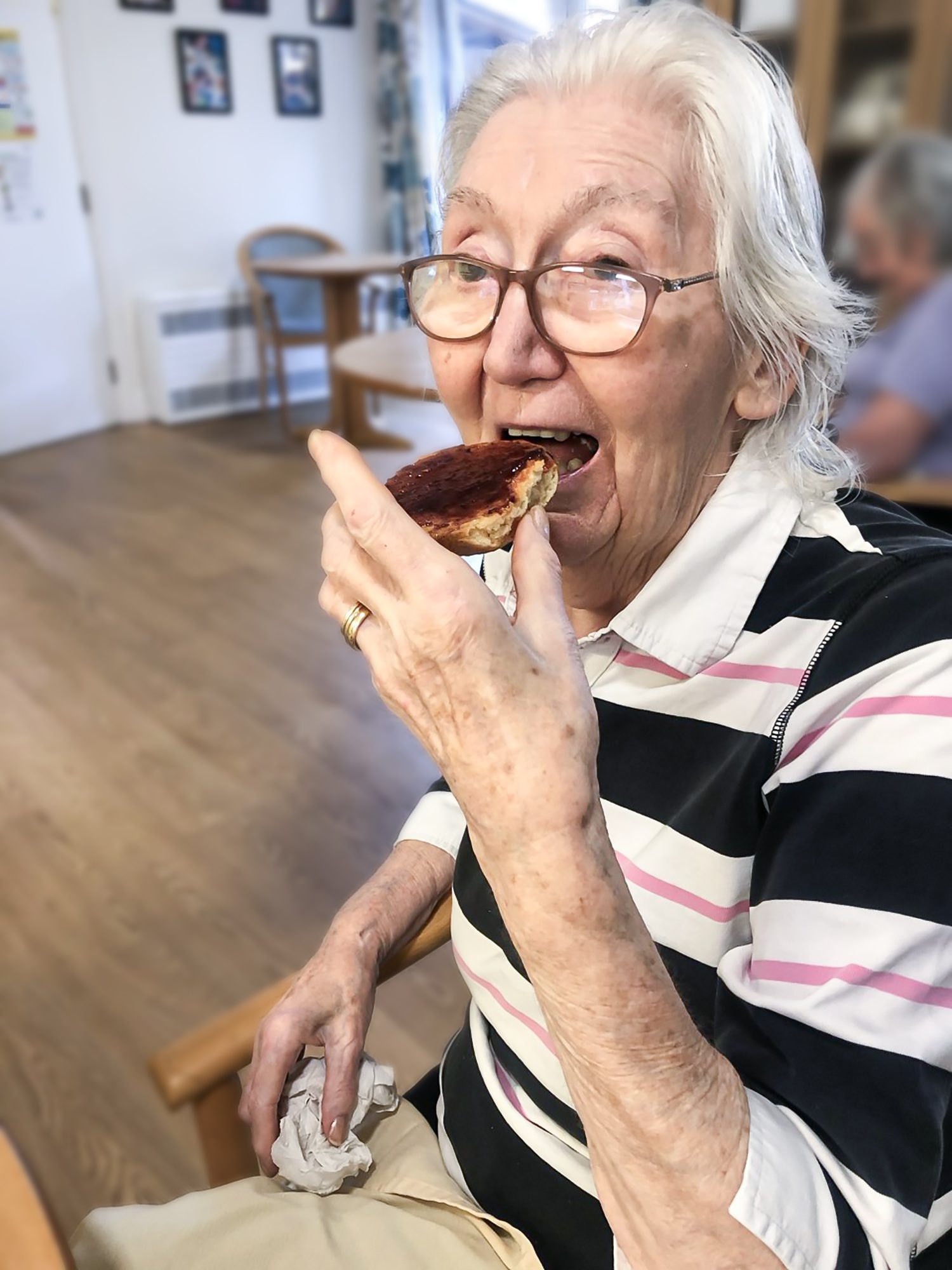 A Bernard Sunley care home resident eating a freshly made scone 