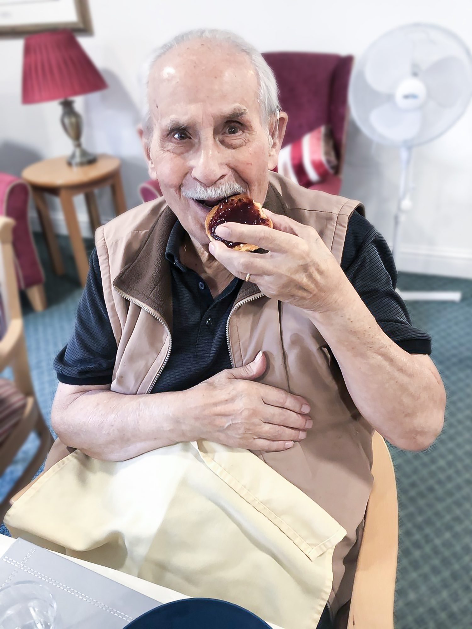 A Bernard Sunley care home resident eating a freshly made scone 