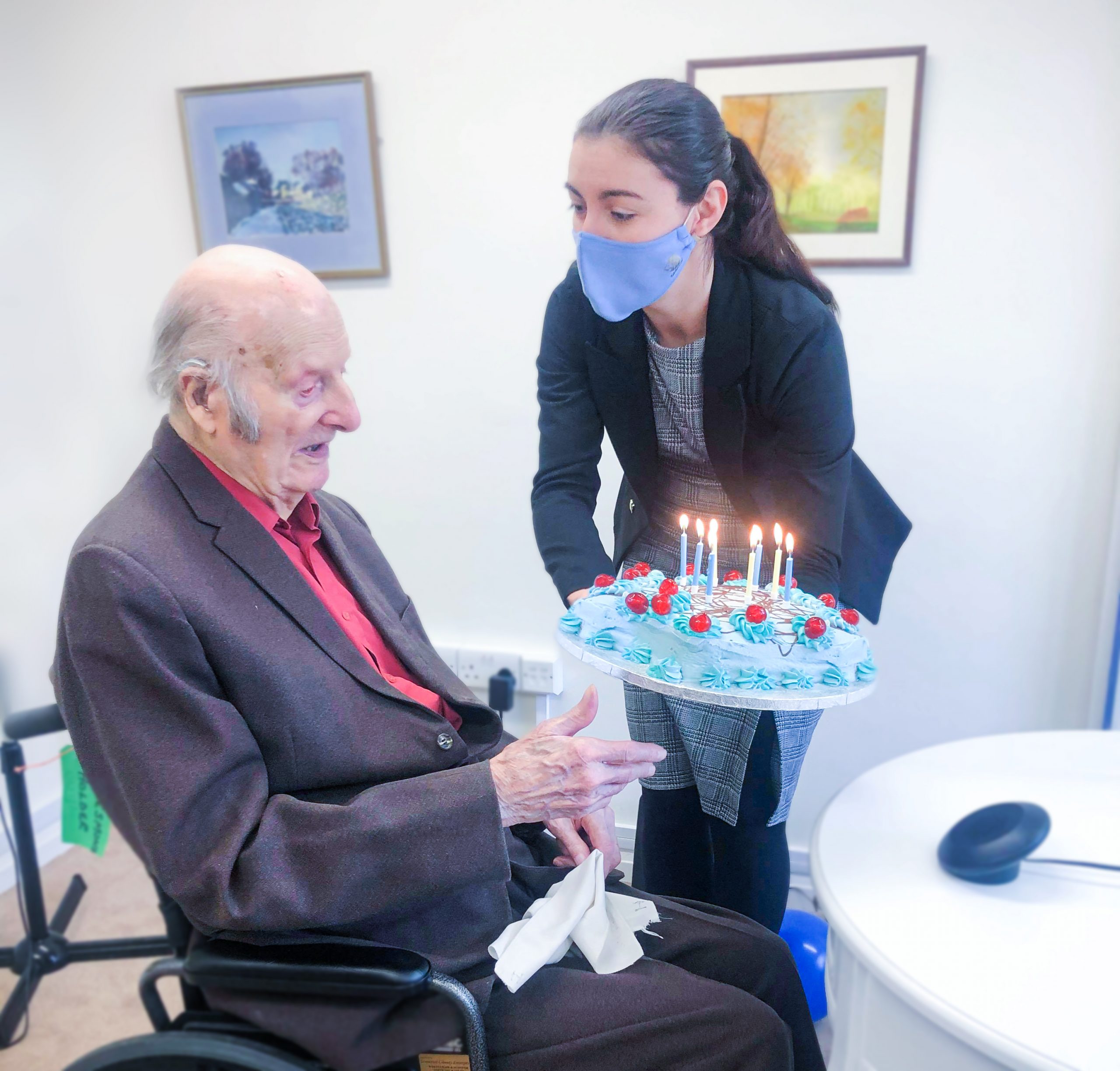 Care Home Manager Alina presenting Desmond with his birthday cake