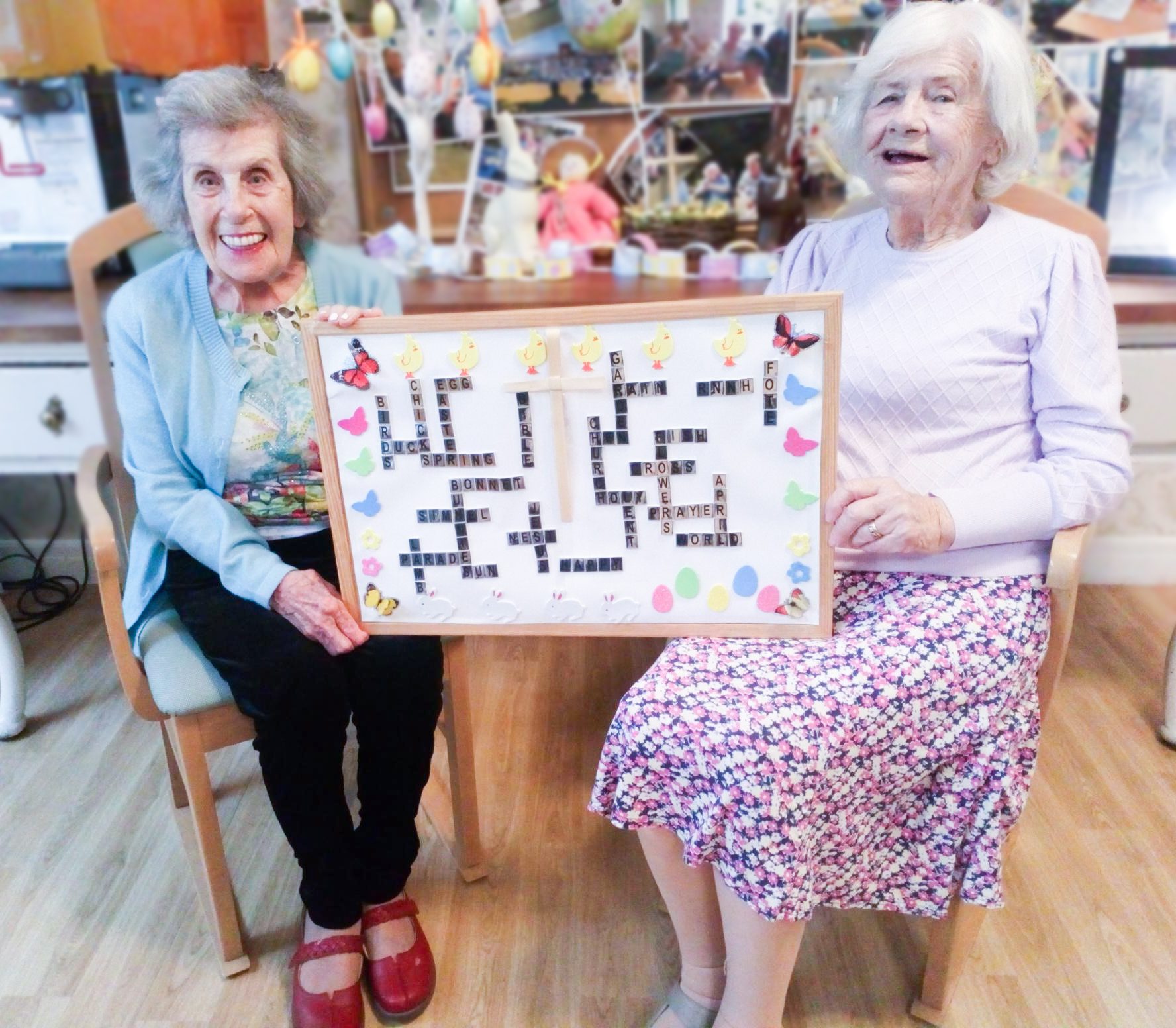 Two RNNH care home residents holding the Easter board