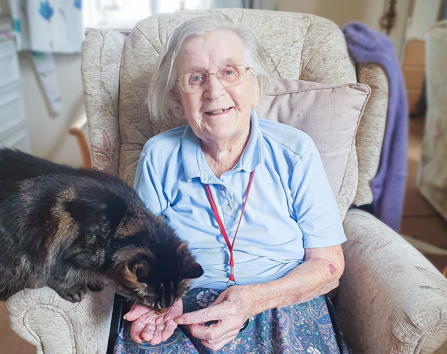 Muriel with Twinkle the Cat smiling on her birthday in July.