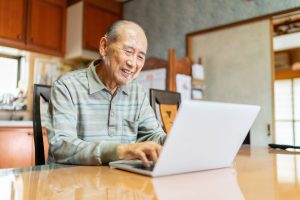 Elderly man using a laptop to stay in touch