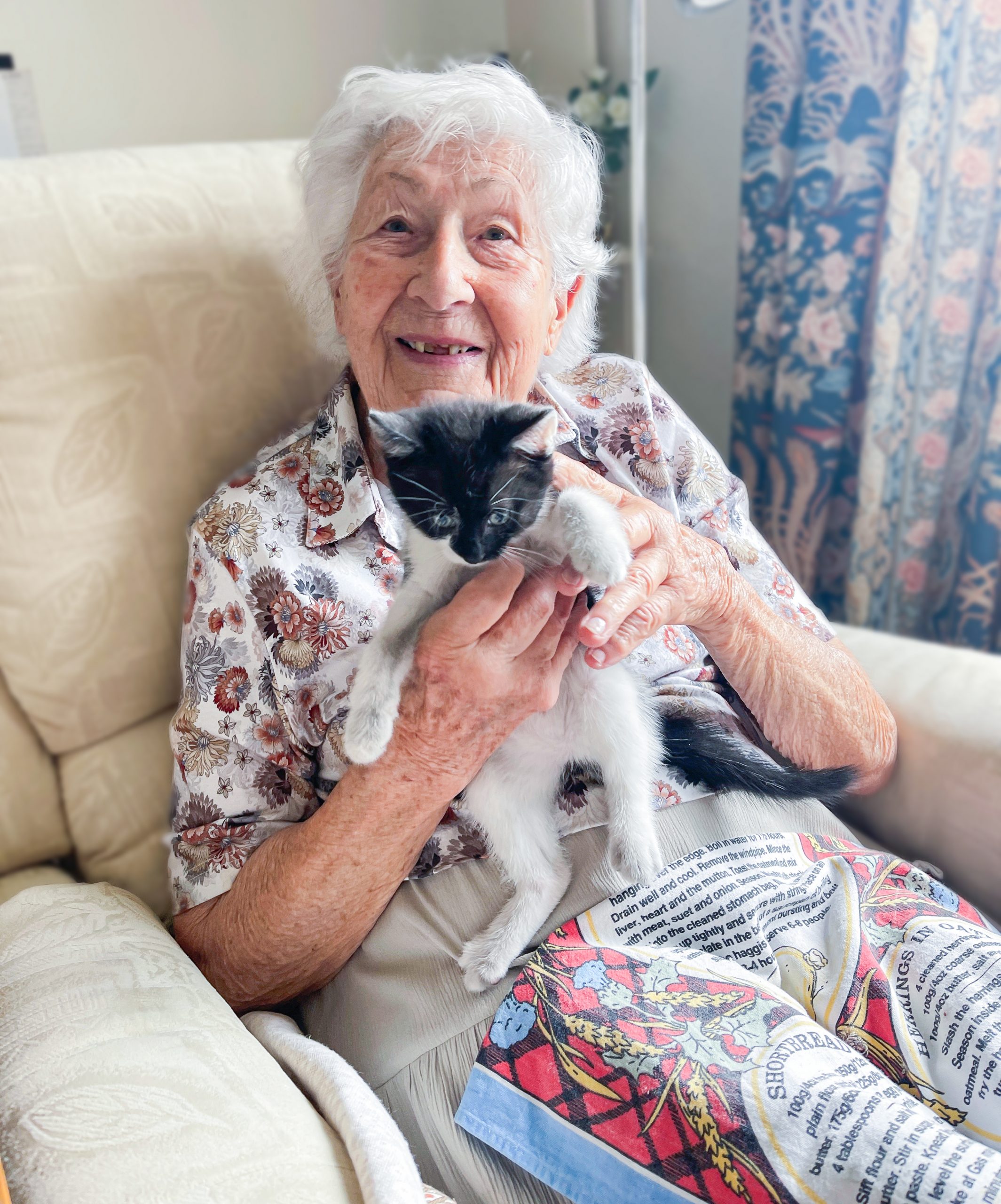 A resident smiling with Slippers the kitten