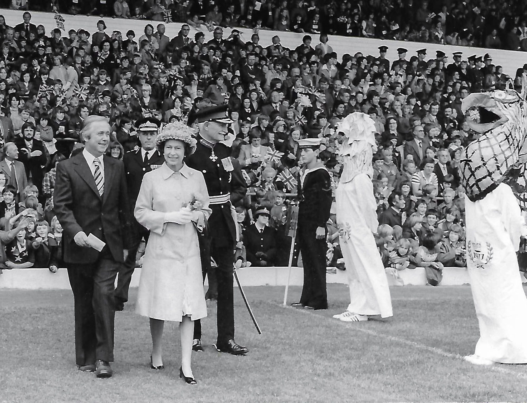 The Queen being escorted by Donald. 