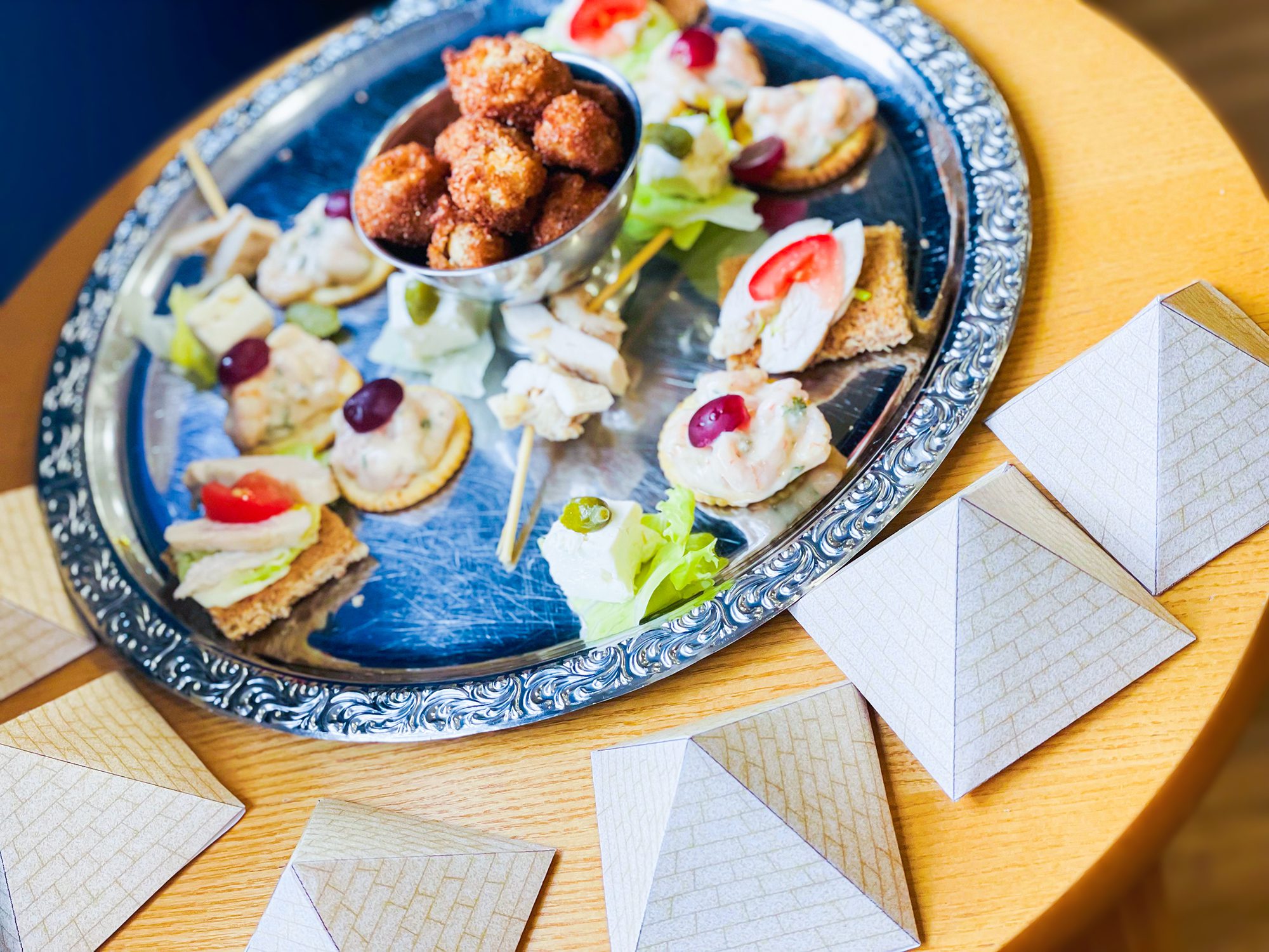 A selection of food with paper pyramids. 