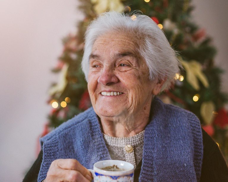 senior woman having a cup of coffee on christmas