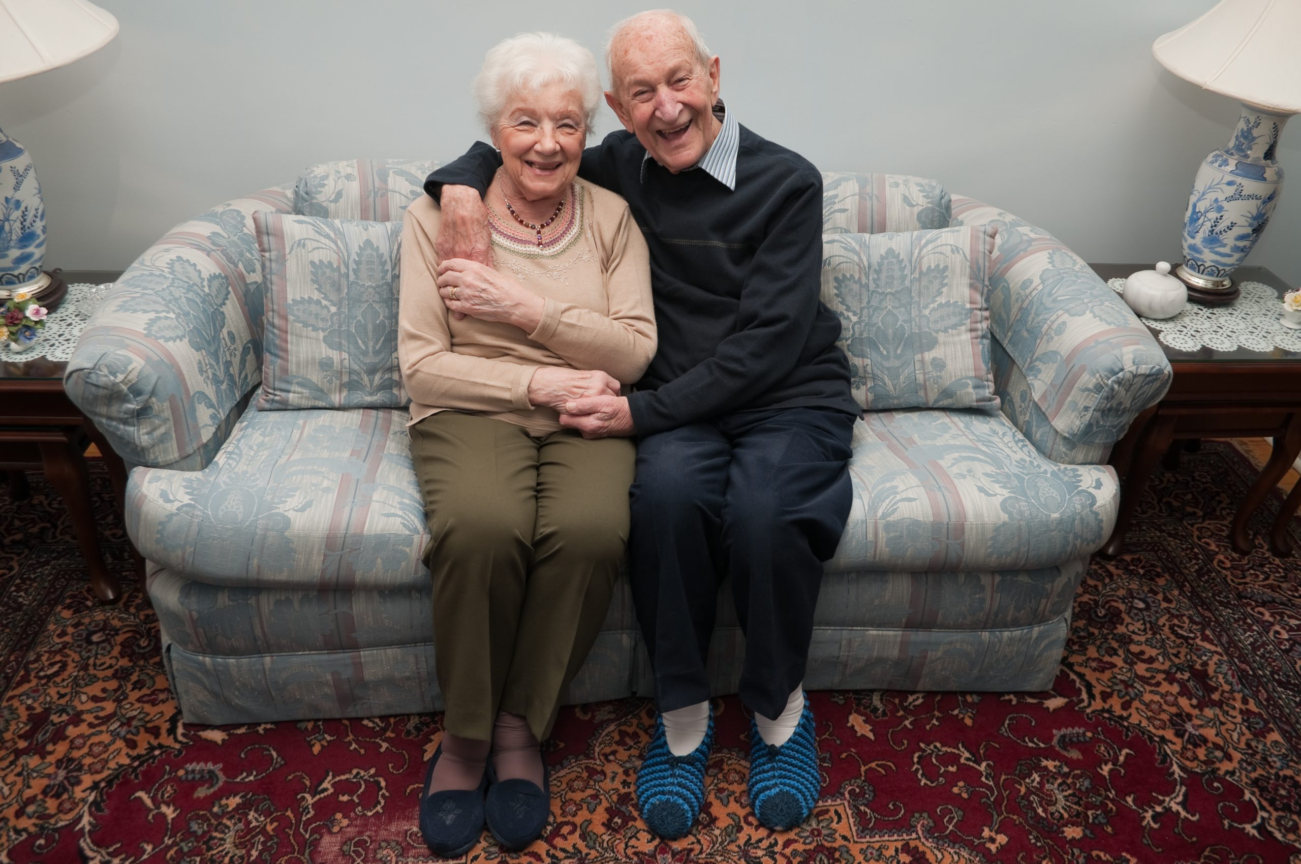 Older people cuddling on a sofa