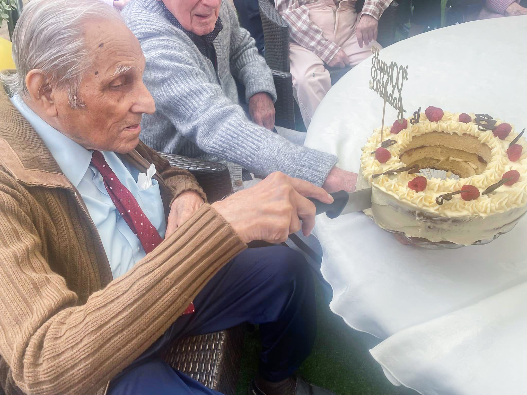 Cedric cutting his birthday cake at his 100th birthday party.