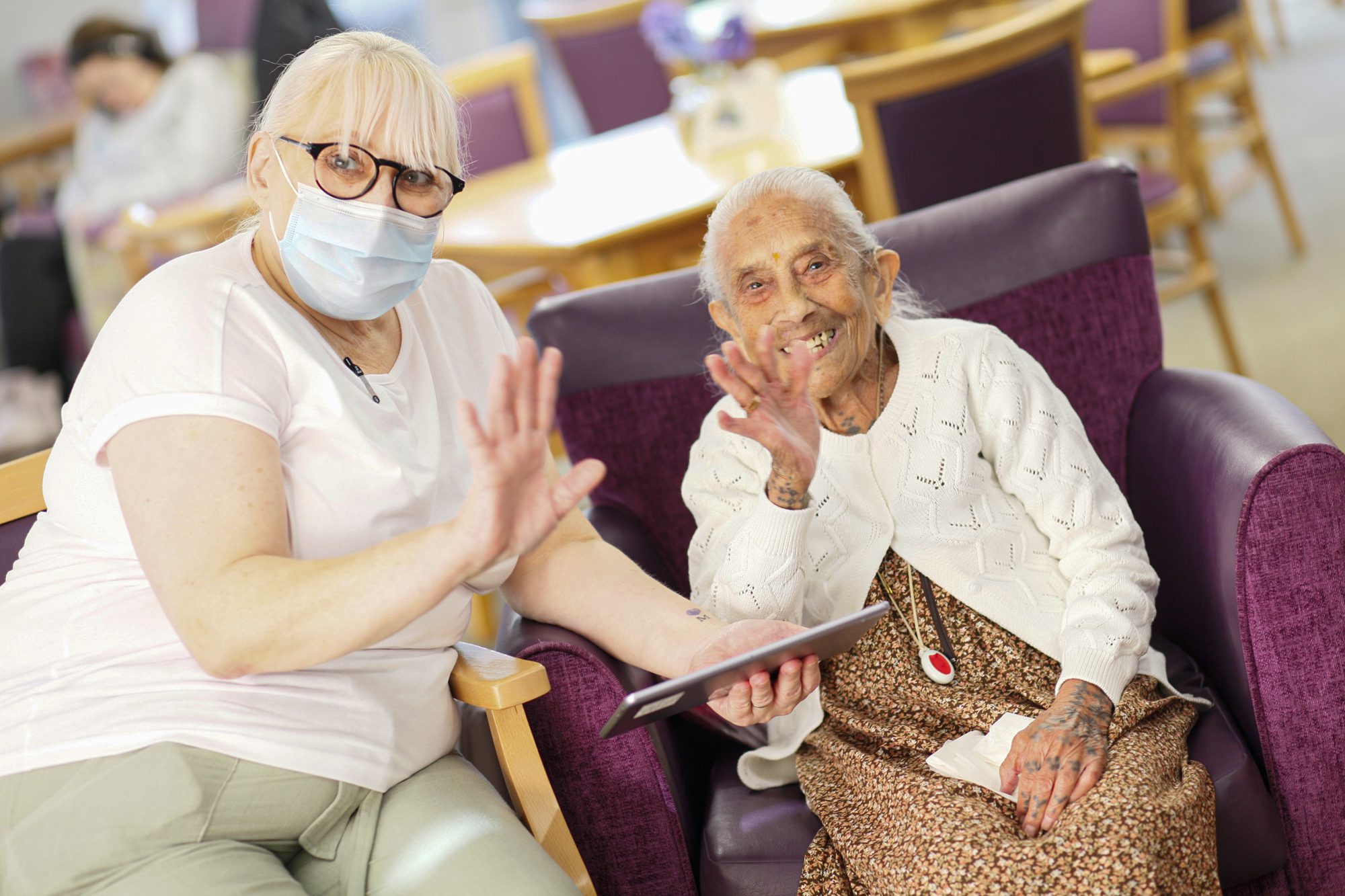 A staff member and Wallington Day Care client waving at the camera