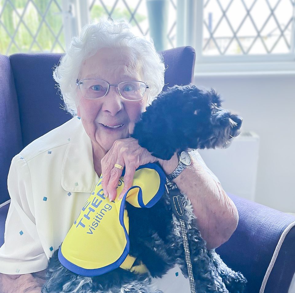 Emma hugging Winnie the Pooch at Little Bramingham Farm care home. 