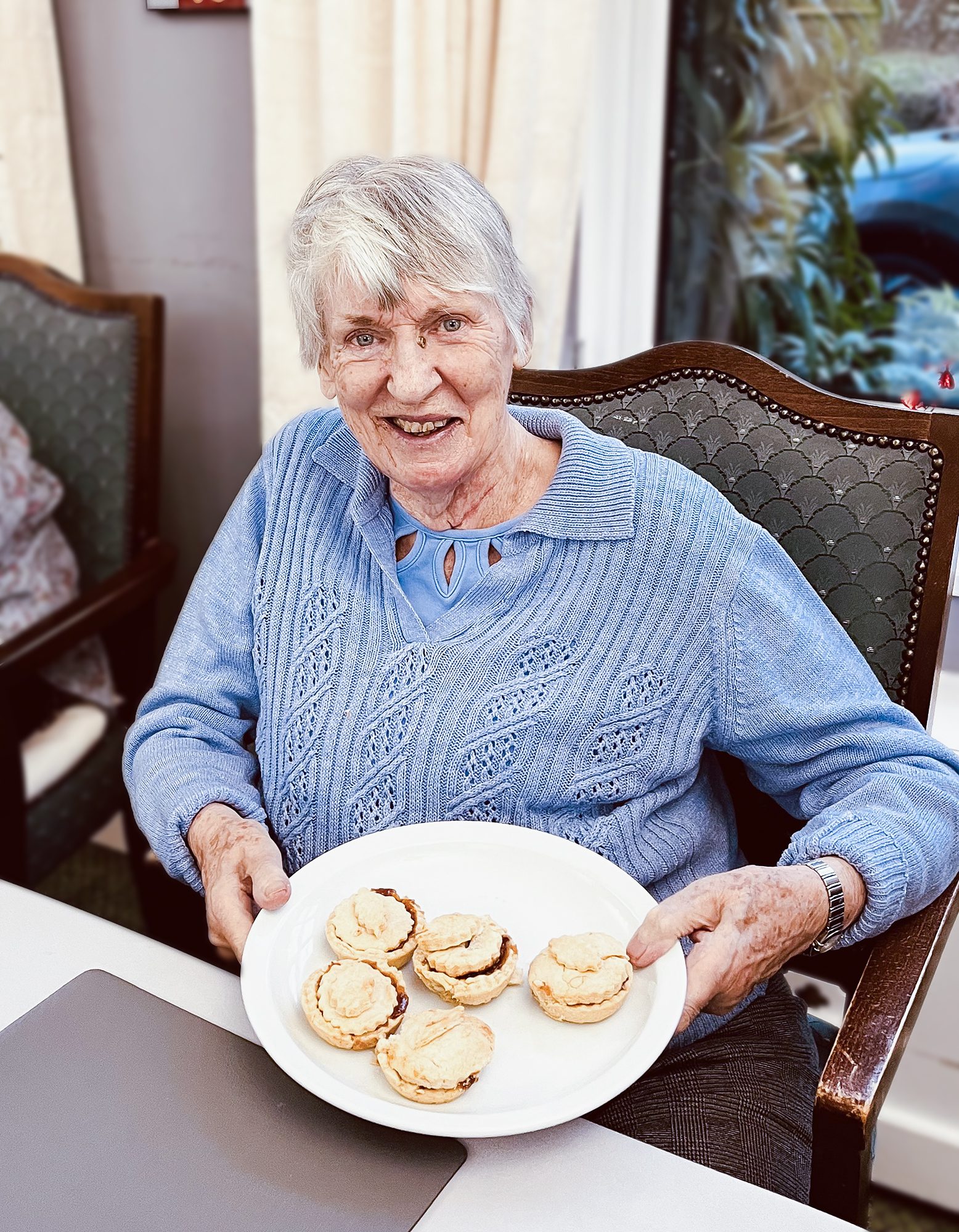 A Redcot resident holding a plate of mince pies.