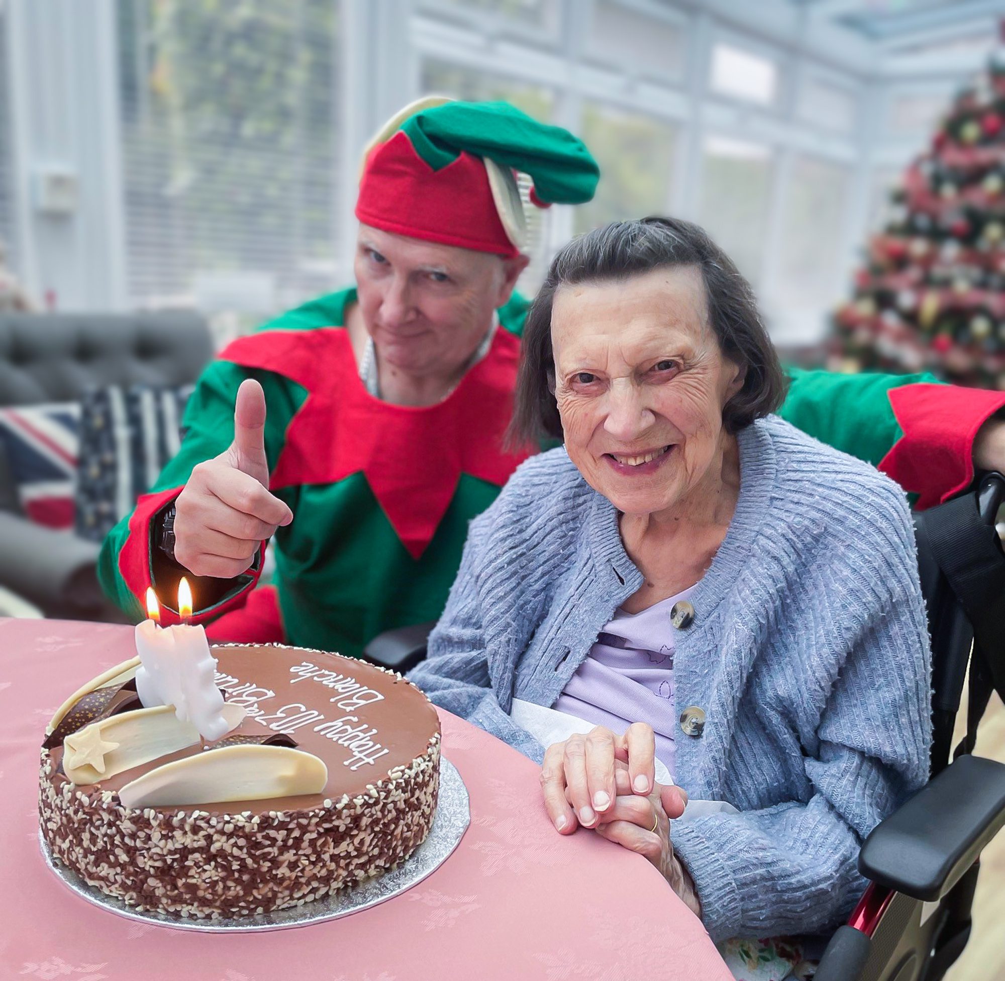 A member of staff helping Blanche celebrate her birthday. 