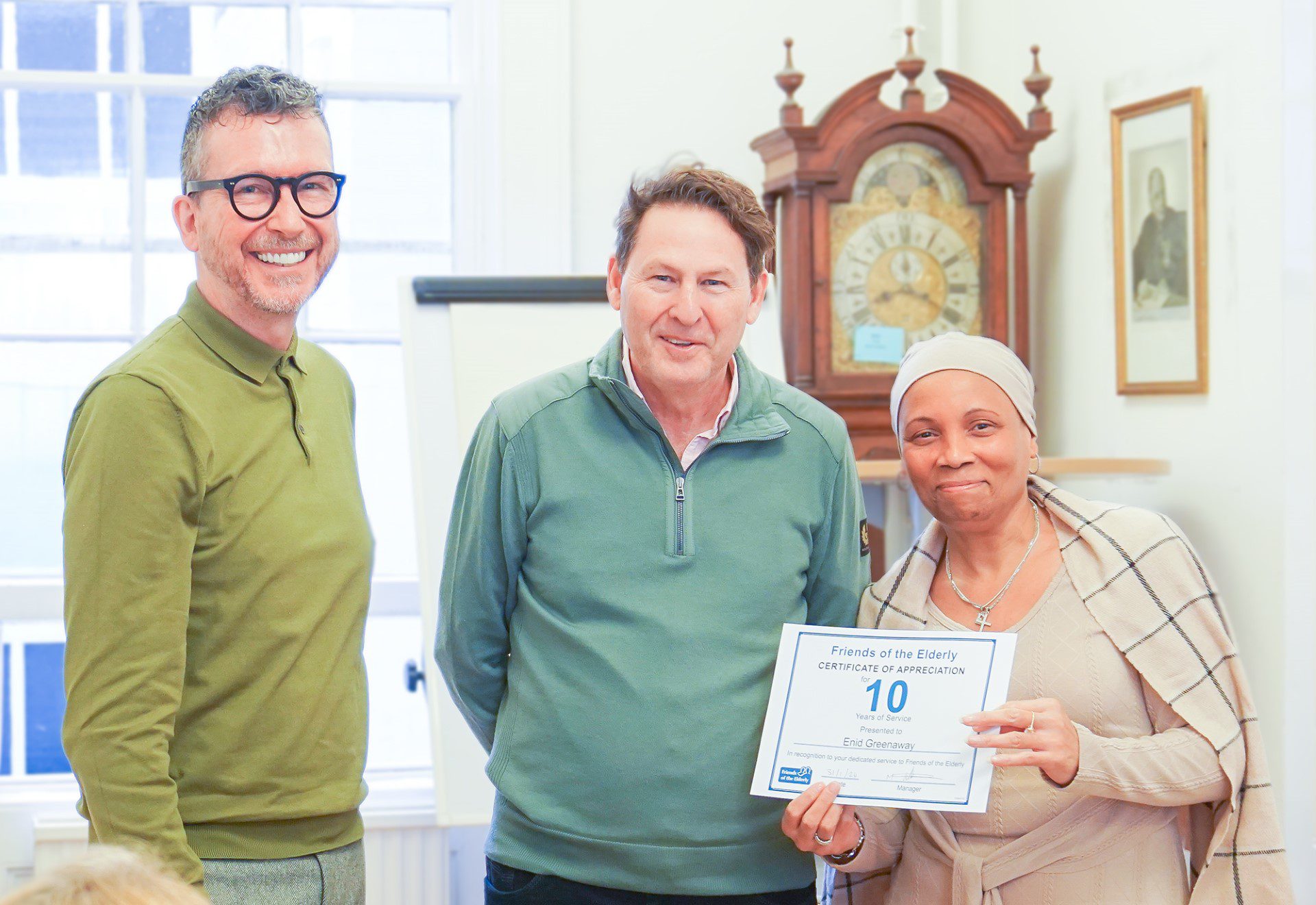 Enid receiving her award stood with Steve and Mark.