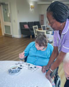 Abi playing bingo with a resident.