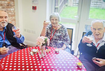 Three residents toast cocktails at the Jazz Cafe
